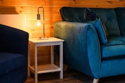 a living room with a blue couch and a table at Rowan in Whithorn