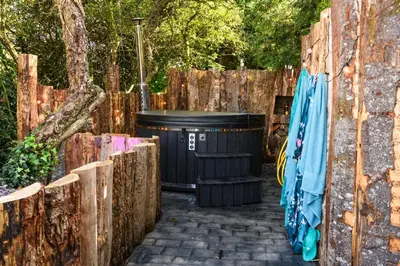 a trash can next to a wooden fence at Ivy in Whithorn