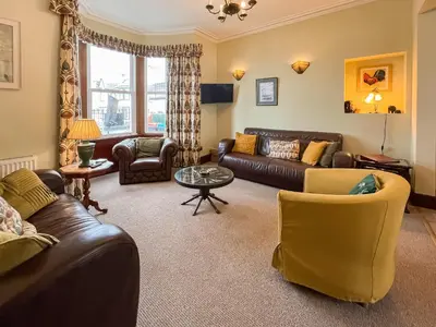 a living room with leather couches and a table at South Haven in Portpatrick