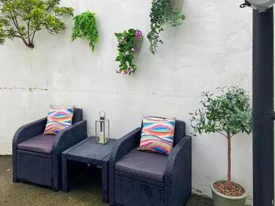 two wicker chairs and a table on a patio at South Haven in Portpatrick