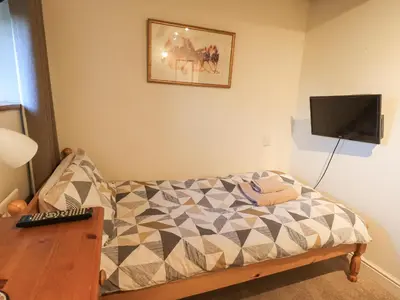 a bedroom with a bed and a tv on the wall at Barn Owl Cottage in Penrith