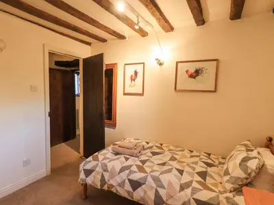 a bedroom with a bed with a comforter on it at Barn Owl Cottage in Penrith