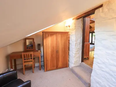 a room with a door and a table and a desk at Barn Owl Cottage in Penrith