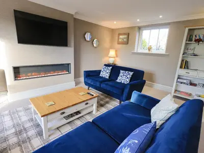a living room with a blue couch and a fireplace at The Elterwater Barn in Workington