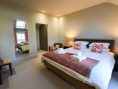 a bedroom with a large bed and a mirror at The Elterwater Barn in Workington