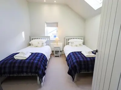 two twin beds in a room with a window at The Elterwater Barn in Workington