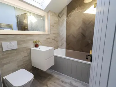 a bathroom with a toilet and a bath tub at The Elterwater Barn in Workington