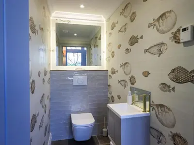 a bathroom with a toilet and a sink and a mirror at The Elterwater Barn in Workington