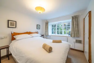 a bedroom with a large white bed with a window at Ghyll Foot - At the foot of Place Fell, Ullswater in Patterdale
