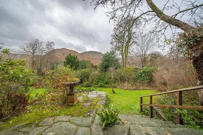 a garden with a stone path and a wooden fence at Ghyll Foot - At the foot of Place Fell, Ullswater in Patterdale
