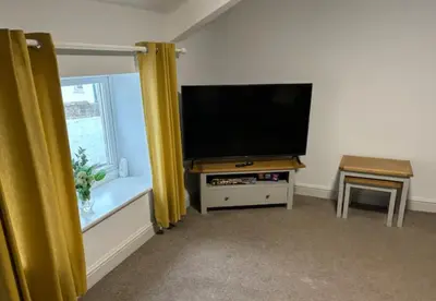 a living room with a flat screen tv and a window at Unique, Large 2 bedroom Flat in Carlisle