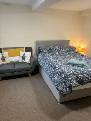 a bedroom with a bed and a couch at Ground Floor Studio in Longtown