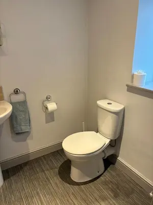 a bathroom with a white toilet and a sink at Ground Floor Studio in Longtown