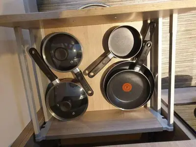 four pots and pans sitting on a shelf at Ground Floor Studio in Longtown