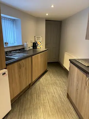 a kitchen with wooden cabinets and a counter top at Ground Floor Studio in Longtown