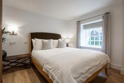 a bedroom with a large bed and a window at Grange Bridge Cottage in Grange