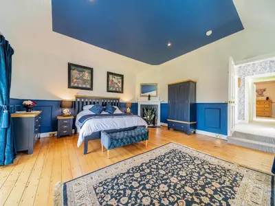 a blue bedroom with a bed and a blue ceiling at Mossknowe Escape in Annan