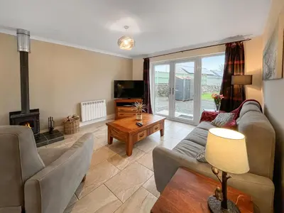 a living room with a couch and a fireplace at Flo's Cottage in Eldrig Village