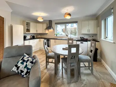 a kitchen and living room with a table and chairs at Flo's Cottage in Eldrig Village