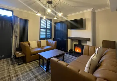 a living room with a couch and a fireplace at Greta House in Keswick