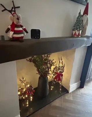 a fireplace with christmas decorations in a room at Greta House in Keswick