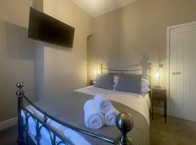 a bedroom with a bed with towels on it at Greta House in Keswick