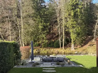 a park with a bunch of picnic tables and a pond at Greta House in Keswick