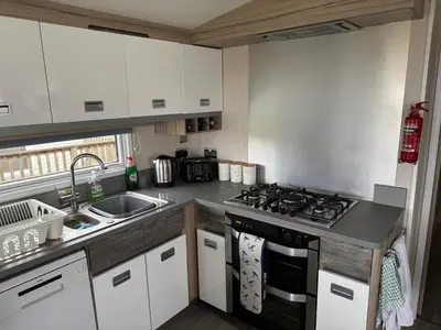 a kitchen with a stove and a sink at The Retreat - Turnberry Holiday Park Amazing Sea View in Girvan