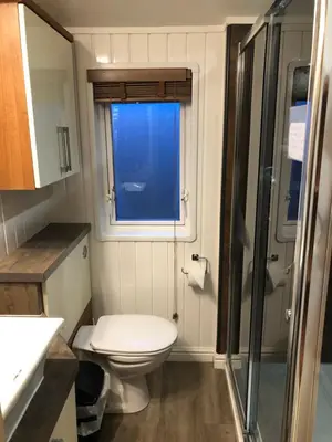 a small bathroom with a toilet and a window at Woodland Lodge in Plumbland