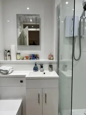 a white bathroom with a shower and a sink at Harbour View Irvine in Irvine