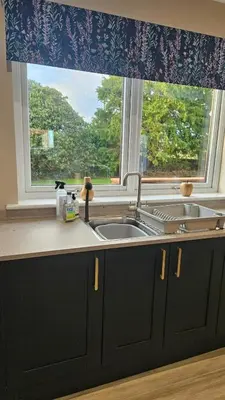 a kitchen counter with a sink and a window at Cosy wee cottage -modern, open plan, parking, EV in Glencaple