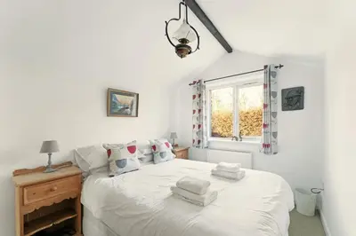 a bedroom with a white bed with towels on it at Rowan Studio Cottage in Grasmere