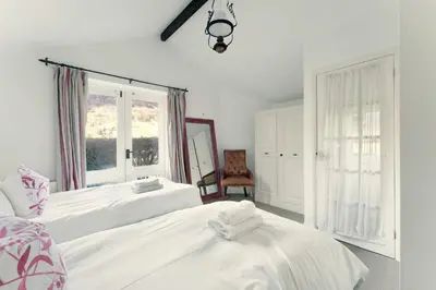 a bedroom with two beds and a window at Rowan Studio Cottage in Grasmere