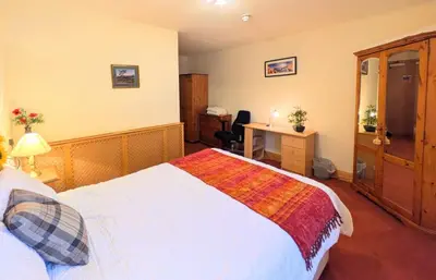 a bedroom with a bed and a desk in it at Fantastic prices for stays of 4 weeks or more - ensuite double rooms -self-catering in Dumfries