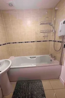 a bathroom with a bath tub and a sink at A Cozy One Bedroom Flat for Two Guests in Carlisle