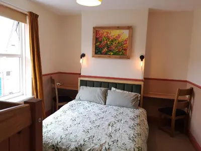 a bedroom with a bed and a painting on the wall at Carlisle Homestay - Family Room in Carlisle
