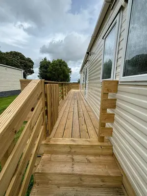 a wooden walkway leading up to a house at 131 Loch View Three Lochs Holiday Park in Newton Stewart