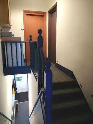 a stairway with a blue railing and a door at Carlisle Homestay - Double Room in Carlisle