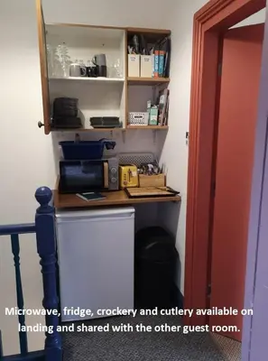 a kitchen with a counter with a refrigerator and a shelf at Carlisle Homestay - Double Room in Carlisle