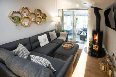 a living room with a couch and a fireplace at Hidden Hive in Gretna