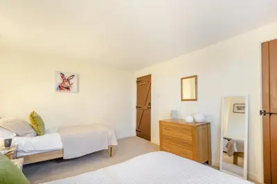 a white bedroom with two beds and a mirror at 2 Bed in Greystoke oc-s30412 in Greystoke