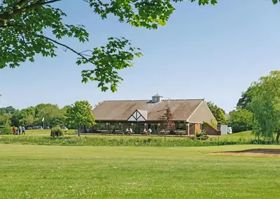 a building on a golf course with a green yard at Eden Lodge Retreat in Crosby