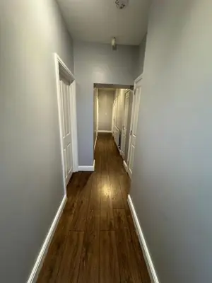 an empty hallway with white walls and wooden floors at Omega Apartment - 3 Bedrooms - Sleeps 5 in Whitehaven