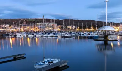 a bunch of boats in a marina at night at Omega Apartment - 3 Bedrooms - Sleeps 5 in Whitehaven