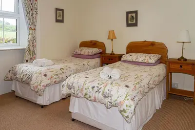 a bedroom with two beds and a window at No2 Chapelton Cottage in Kirkcudbright
