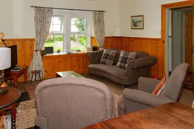 a living room with a couch and chairs and a table at No2 Chapelton Cottage in Kirkcudbright