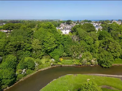 an aerial view of a park with a river and trees at Mount Auldyn House - The Cottage in Ramsey