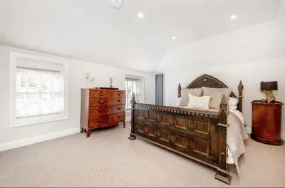 a bedroom with a bed and a dresser and a window at Mount Auldyn House - The Cottage in Ramsey