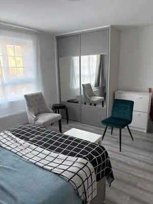 a bedroom with a bed and a chair and a mirror at private Studio with its own kitchen and bathroom in Moffat