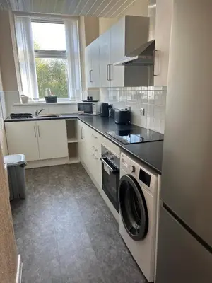 a kitchen with a washer and dryer in it at Hillhead Apartment in Coylton